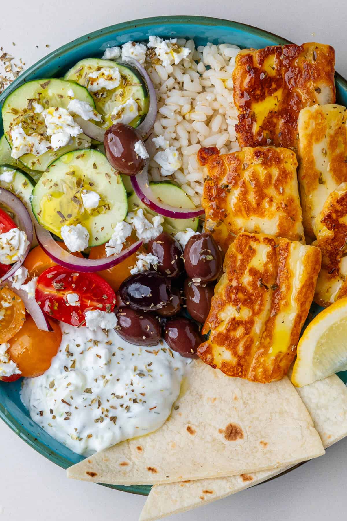 Greek bowl with olives, halloumi, salad, pita bread and tzatziki