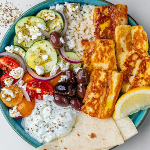 Greek bowls with olives, halloumi, salad, pita bread and tzatziki