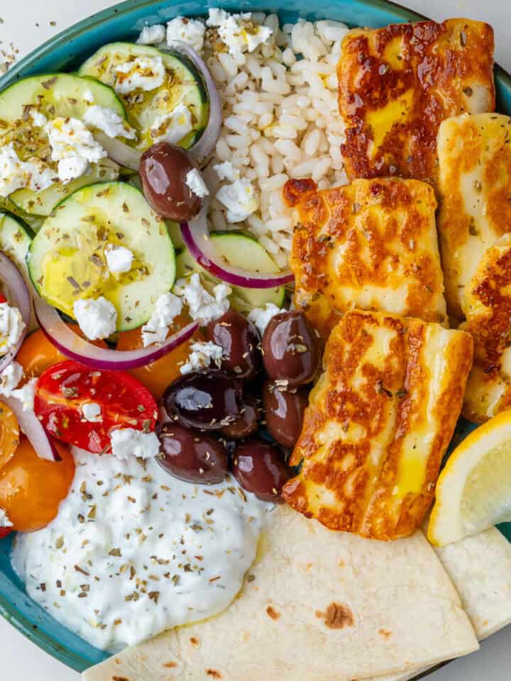 Greek bowls with olives, halloumi, salad, pita bread and tzatziki