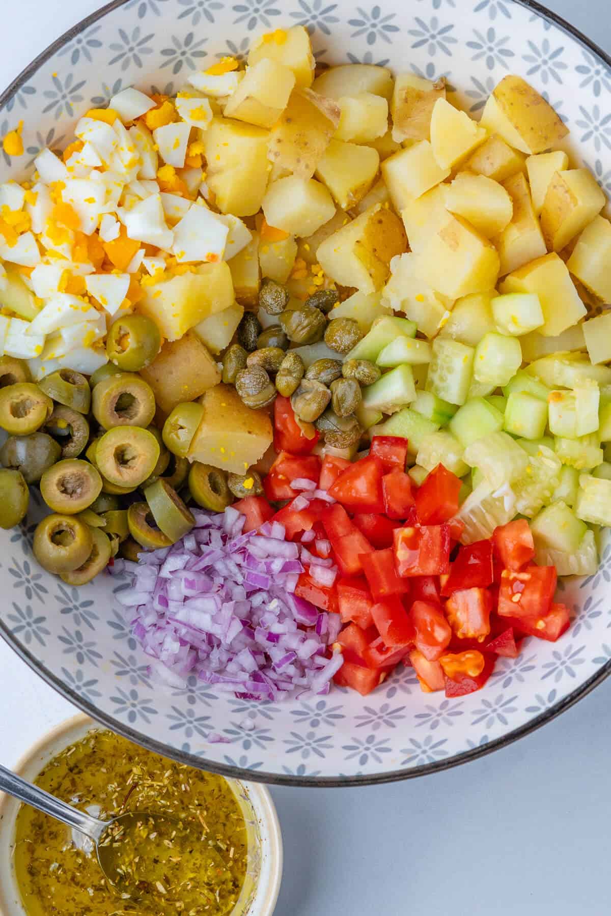 Chopped salad ingredients in a bowl with the dressing on the side