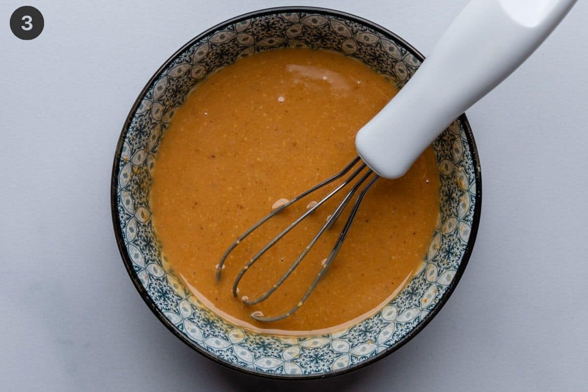 Wet ingredients prepared in a small bowl with whisk