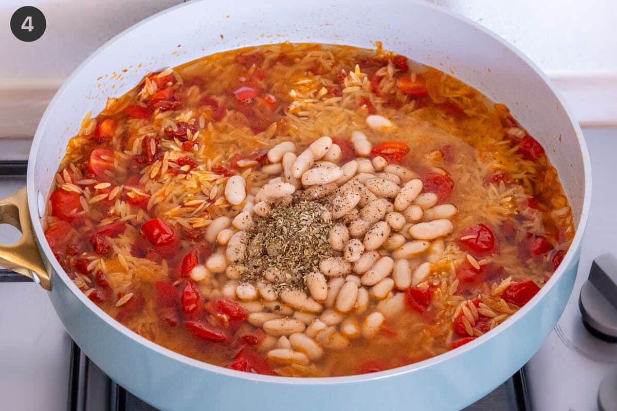 Cannelini beans, oregano and pasta added to the pan