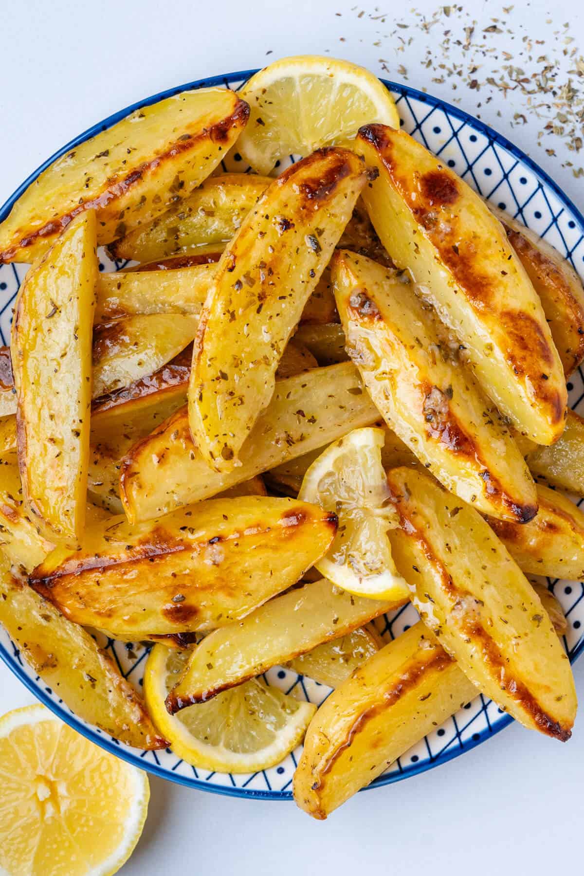 Bowl of Greek lemon potatoes in a bowl with slices of lemon