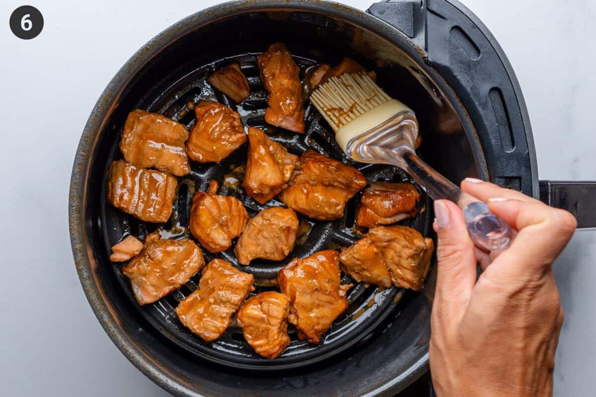 Marinade being brushed over salmon at half way point