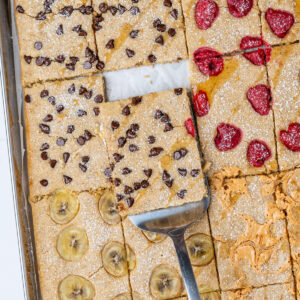 Sheet pan pancakes with a piece coming out of the tray with a spatula