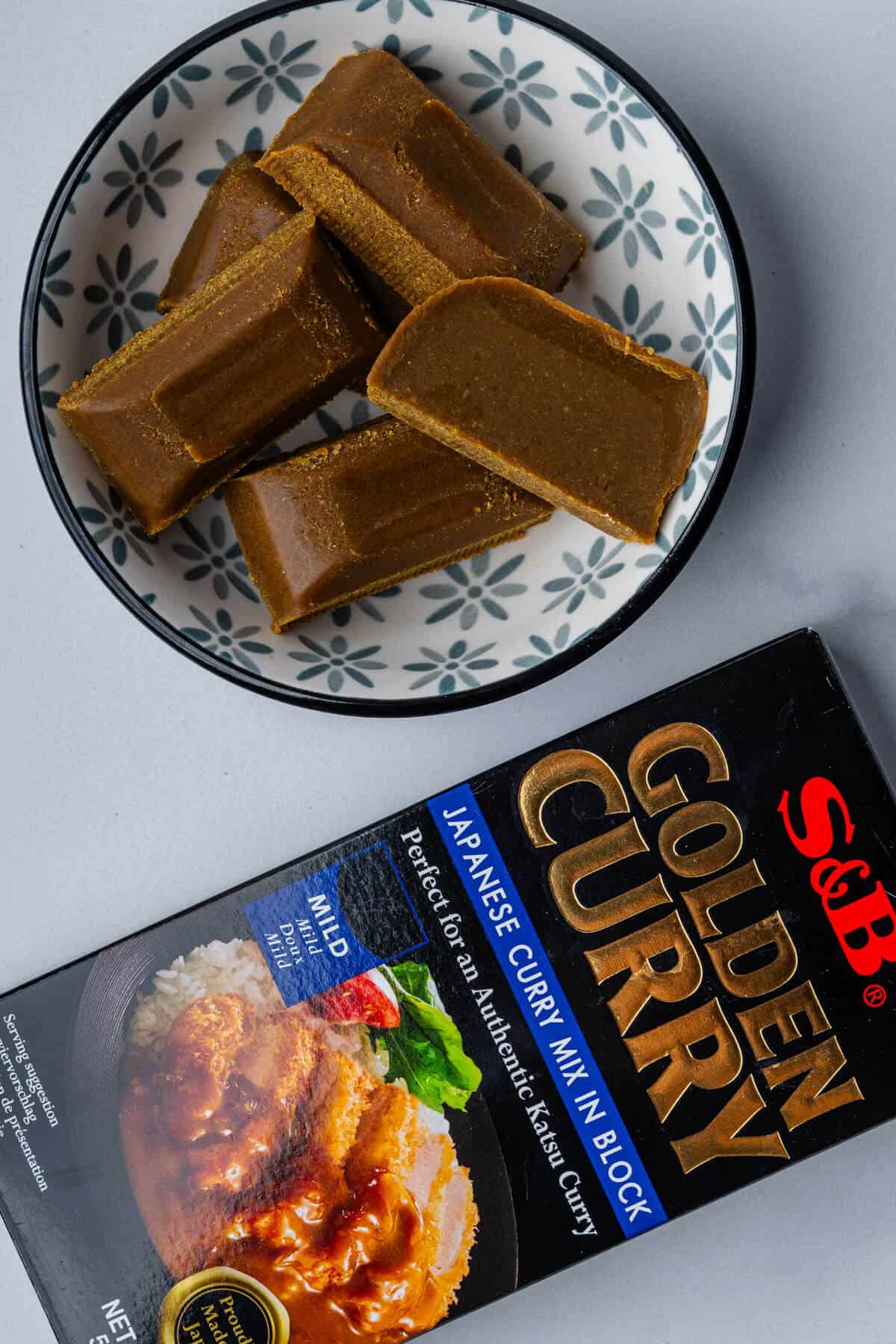 Golden curry mix in a bowl with original box