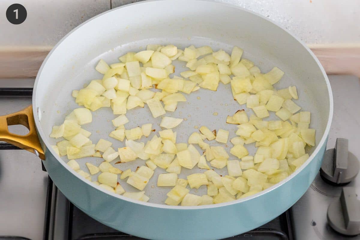 Onions being sautéed in a pan