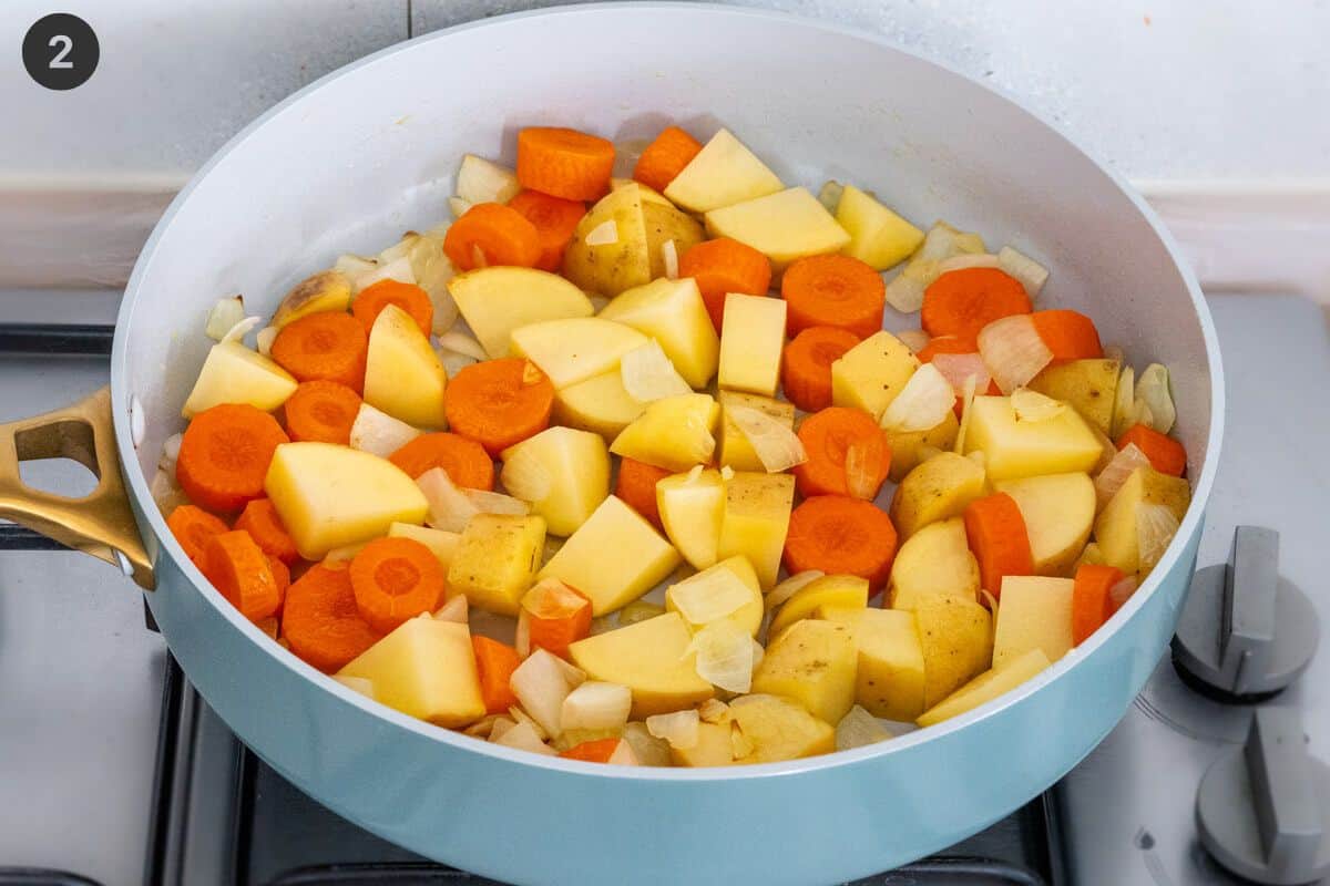 Carrots and potatoes added to a pan