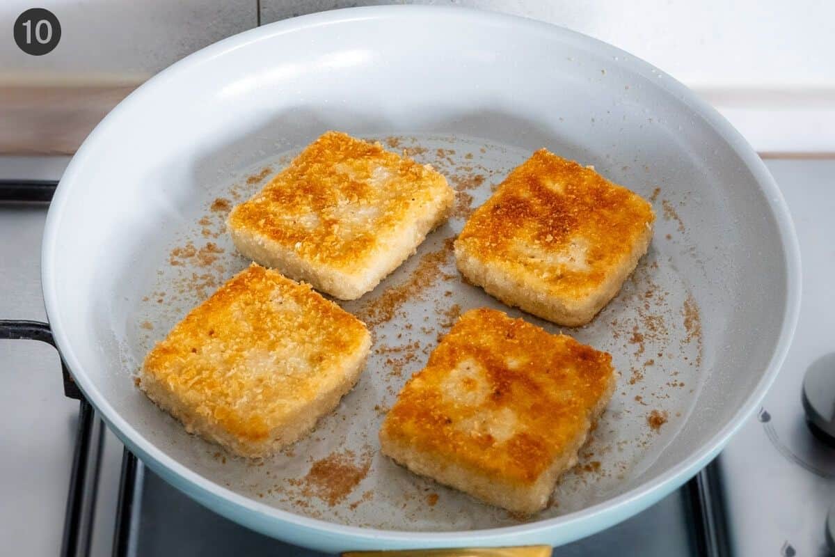 Tofu flipped and golden in a pan