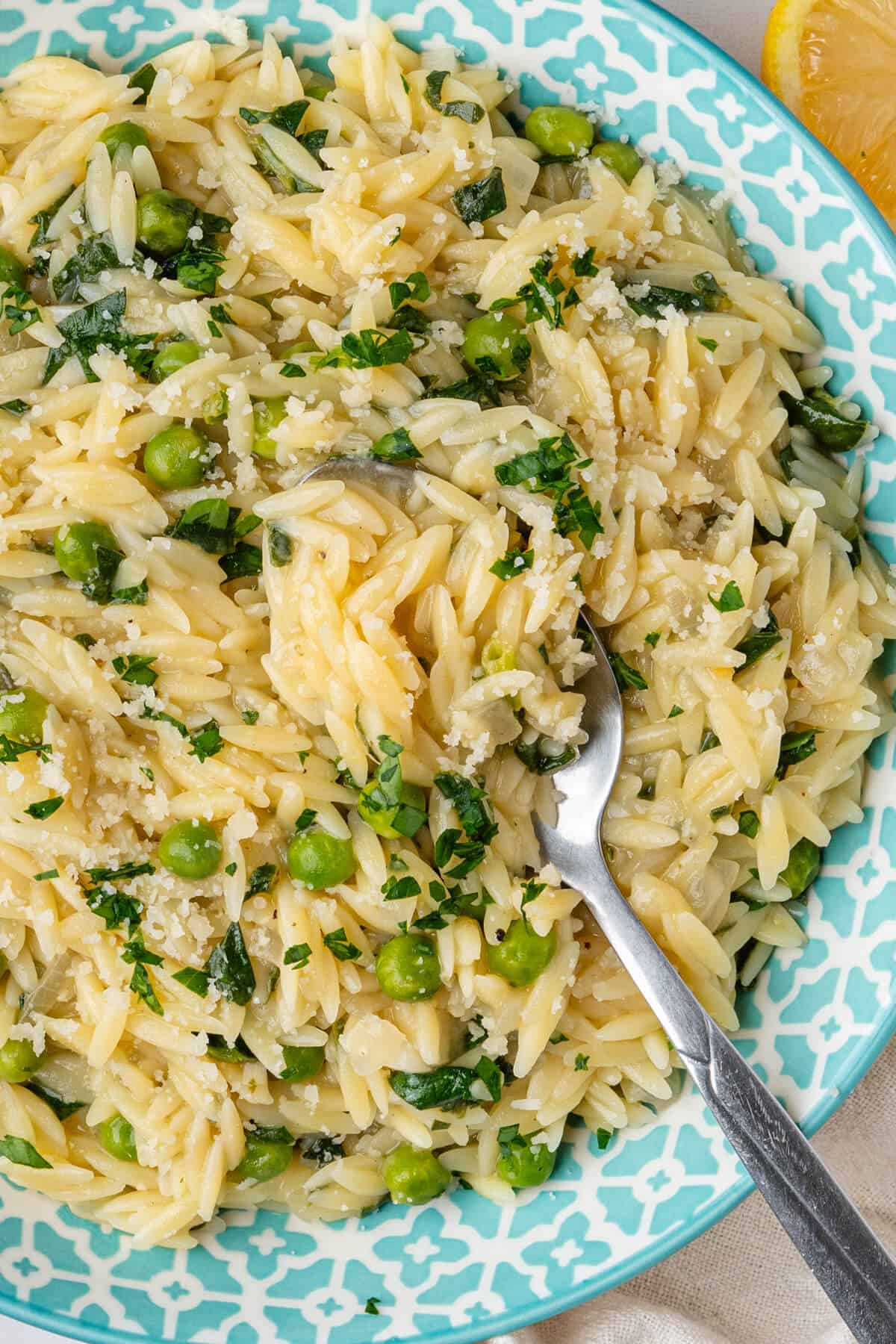 Spoon inside a bowl of lemon orzo