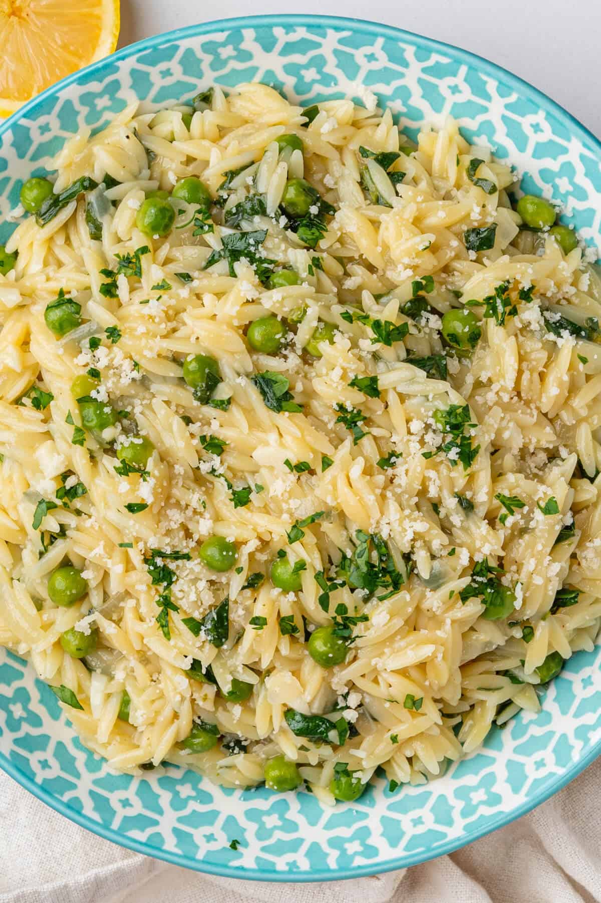 Lemon orzo with peas and spinach, topped with parmesan cheese