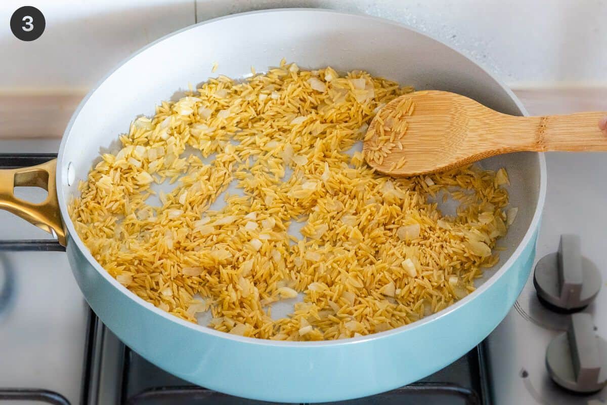 Orzo added to the large pan with onion