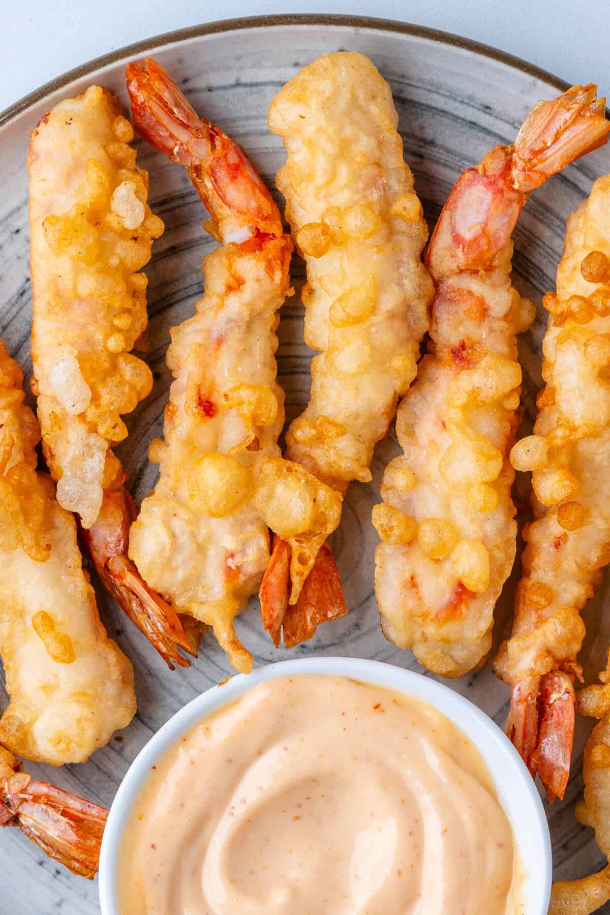 Shrimp tempura on a plate with a side of sriracha aioli