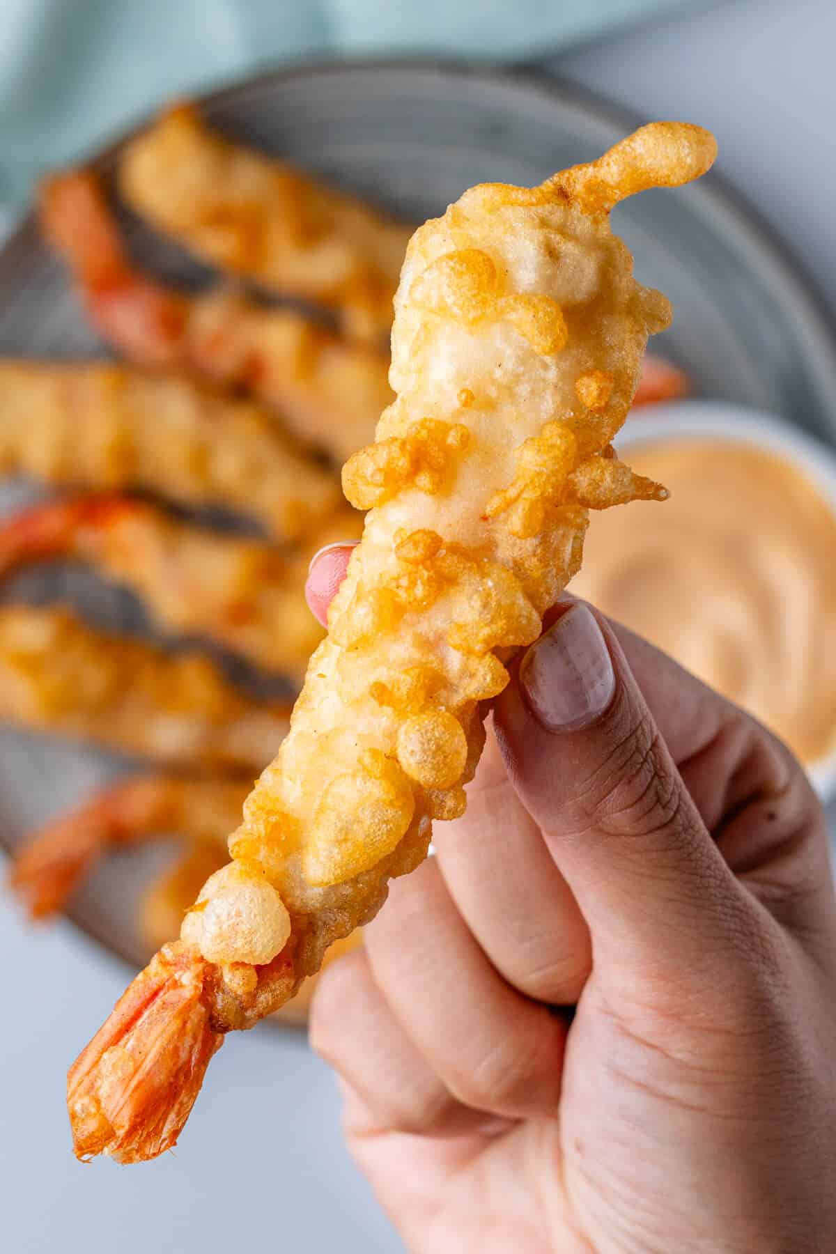 Piece of tempura being held up to show the texture