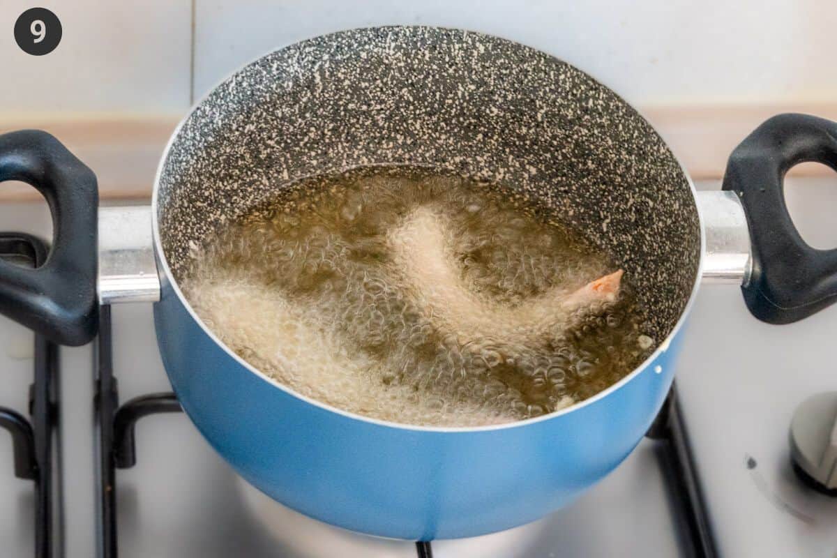 Shrimp being fried in a pot of oil