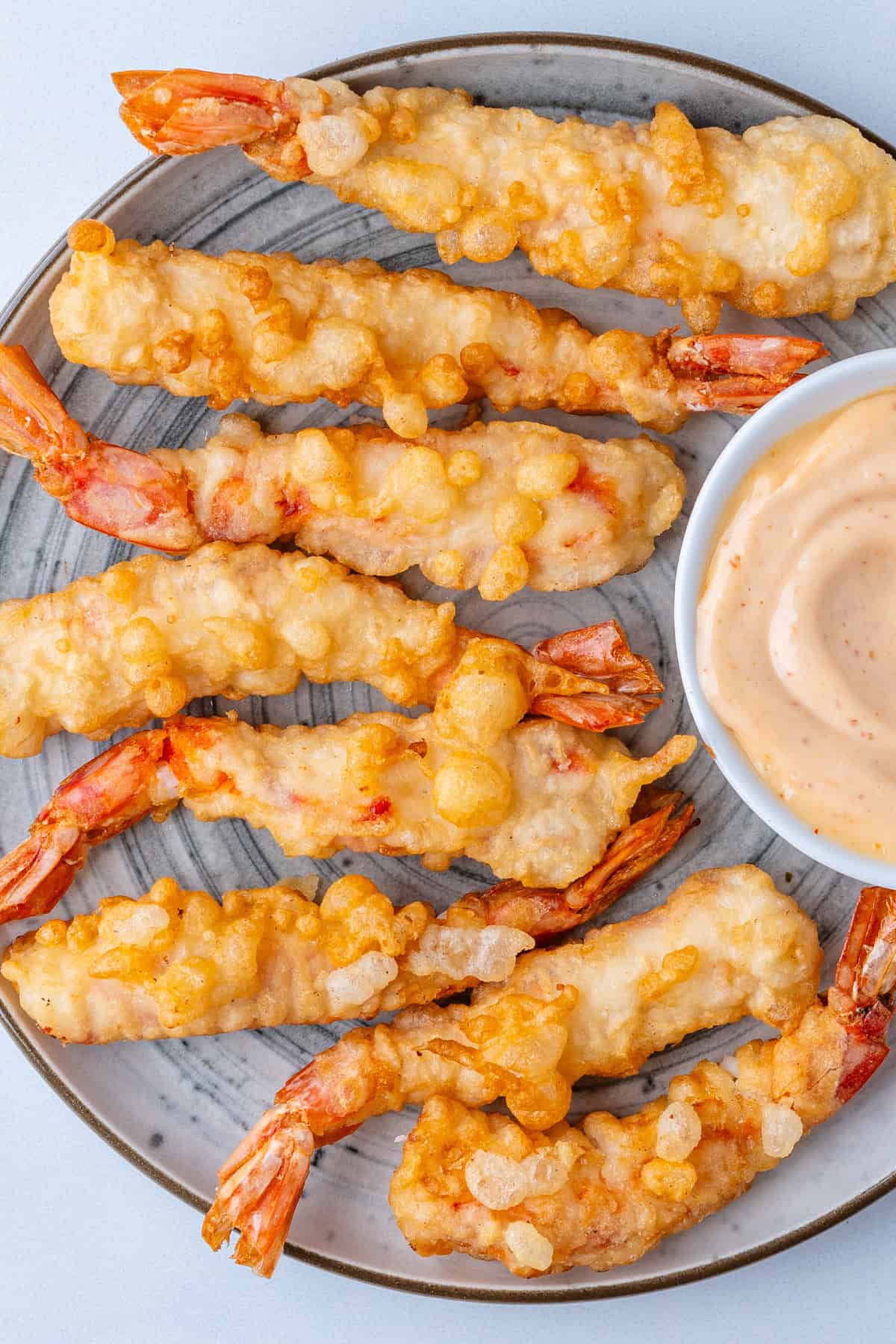 Shrimp tempura on a plate with sriracha aioli