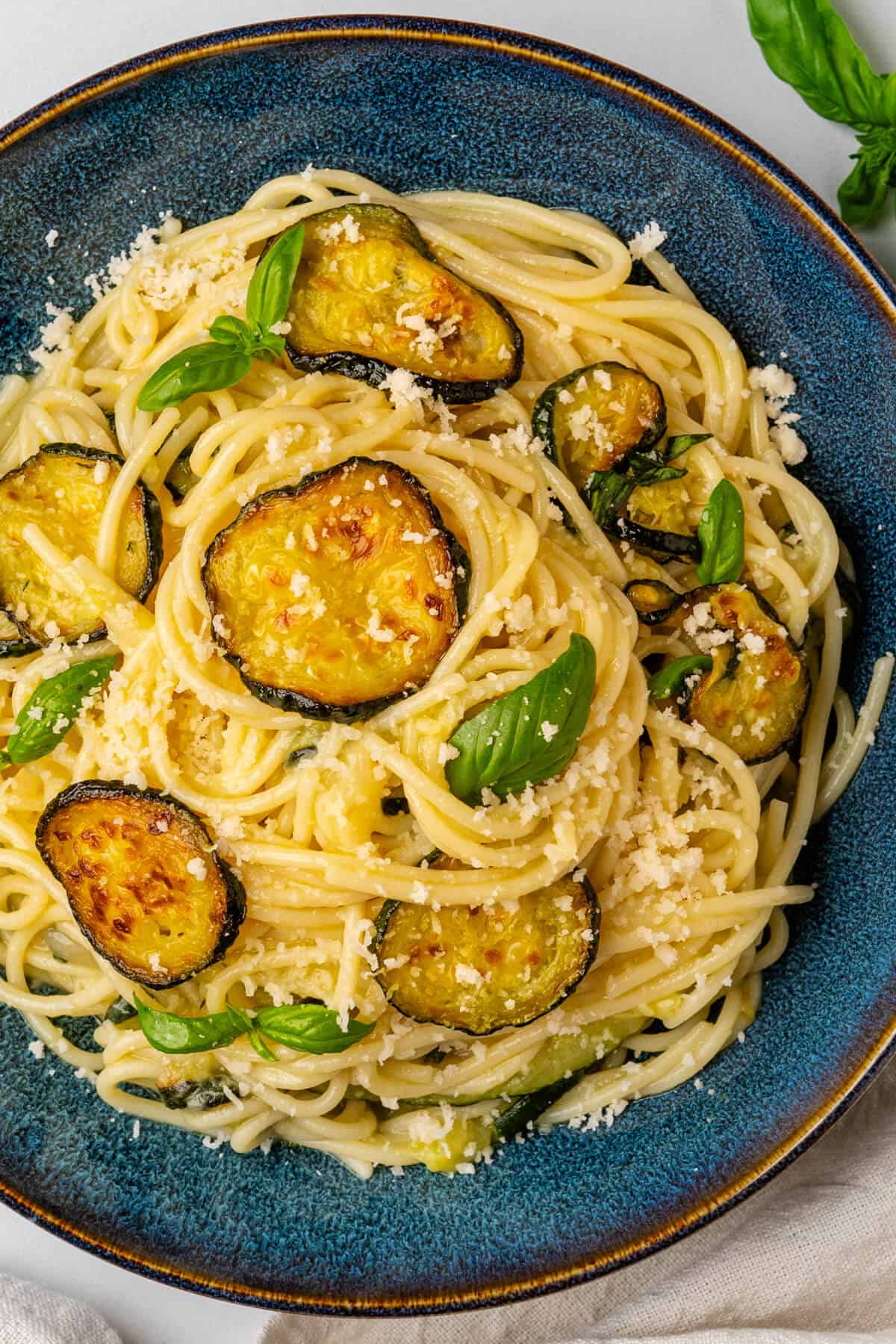 Spaghetti alla Nerano served in a bowl with grated parmesan on top