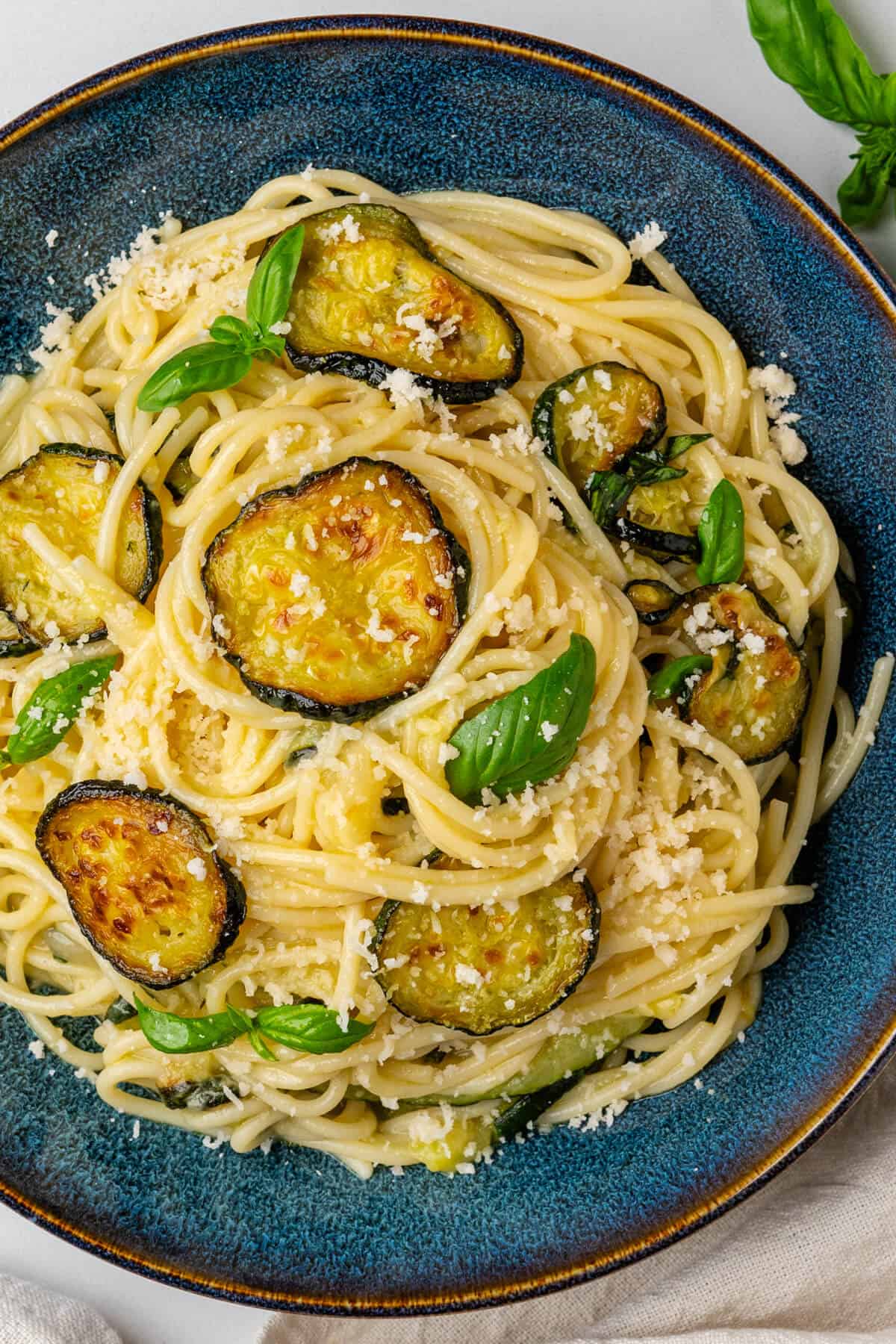 Spaghetti alla Nerano served in a bowl with grated parmesan on top