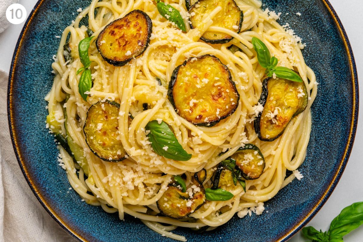 Final bowl of spaghetti alla nerano with grated parmesan and fresh basil on top