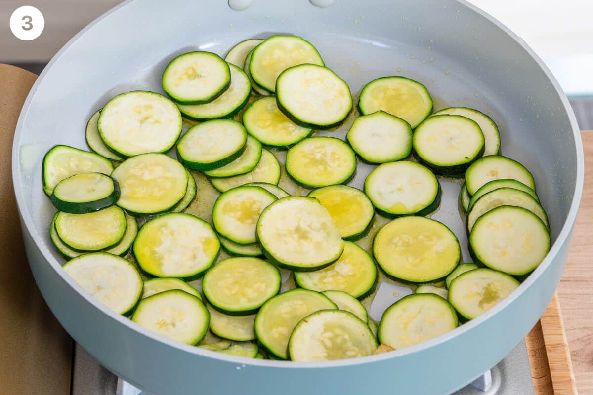 Zucchini being fried with olive oil in a pan