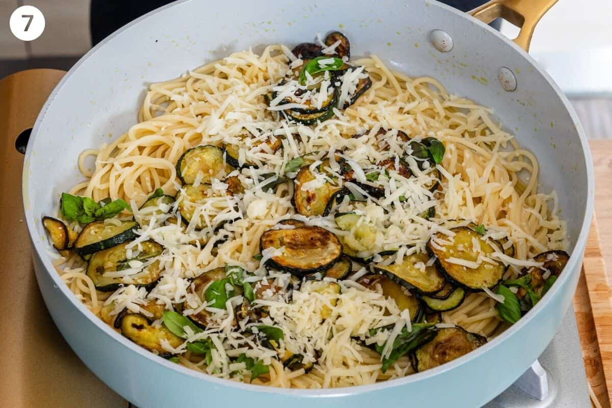 Pasta, cheese and fried zucchini with pasta water in a pan