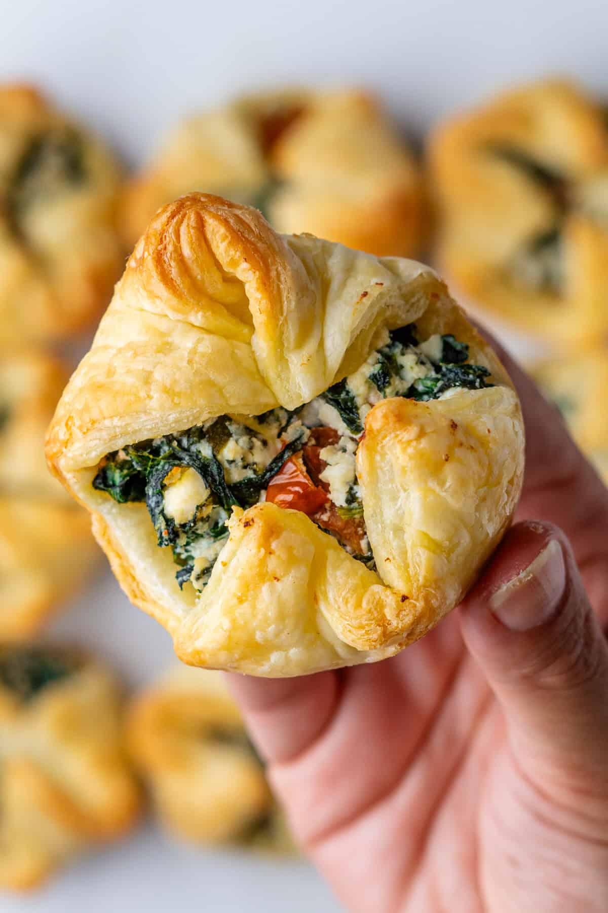 Close up of a spinach puff being held