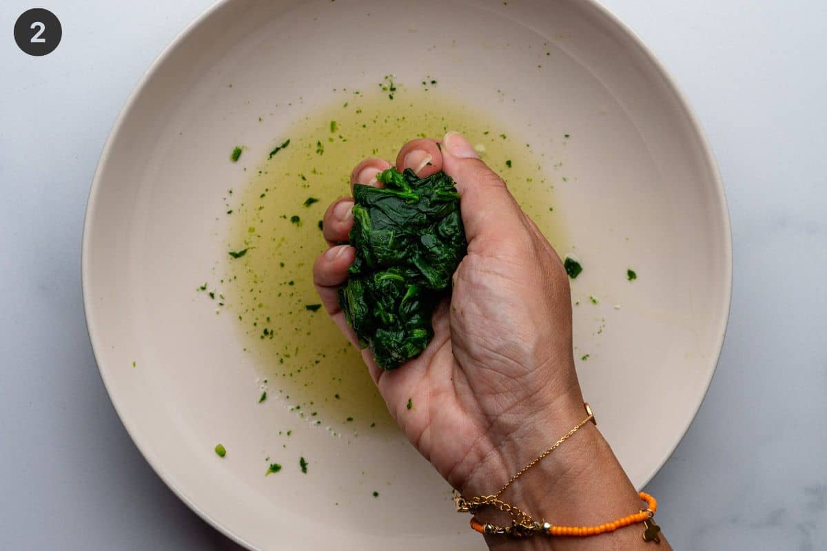 Frozen spinach being squeezed to remove liquid