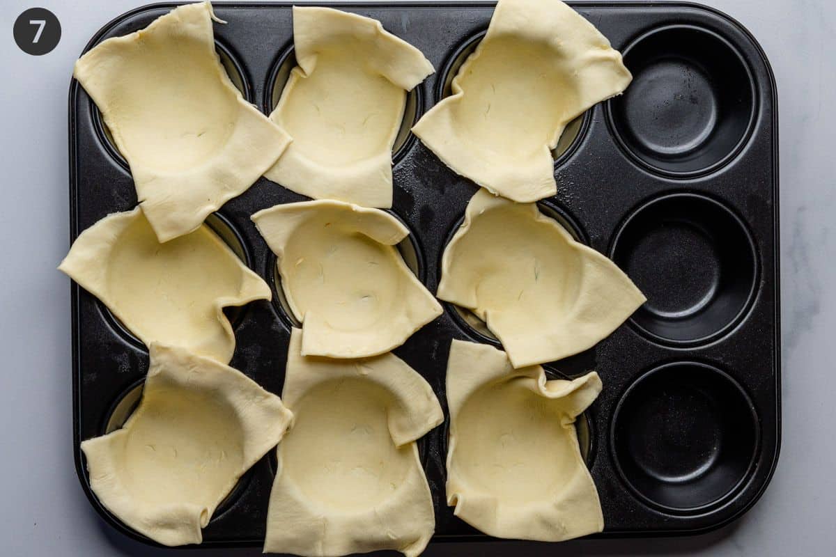 Puff pastry sheets placed into muffin tin