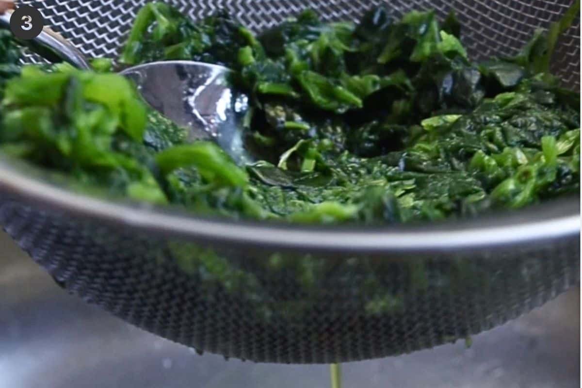 Excess liquid being squeezed out of spinach