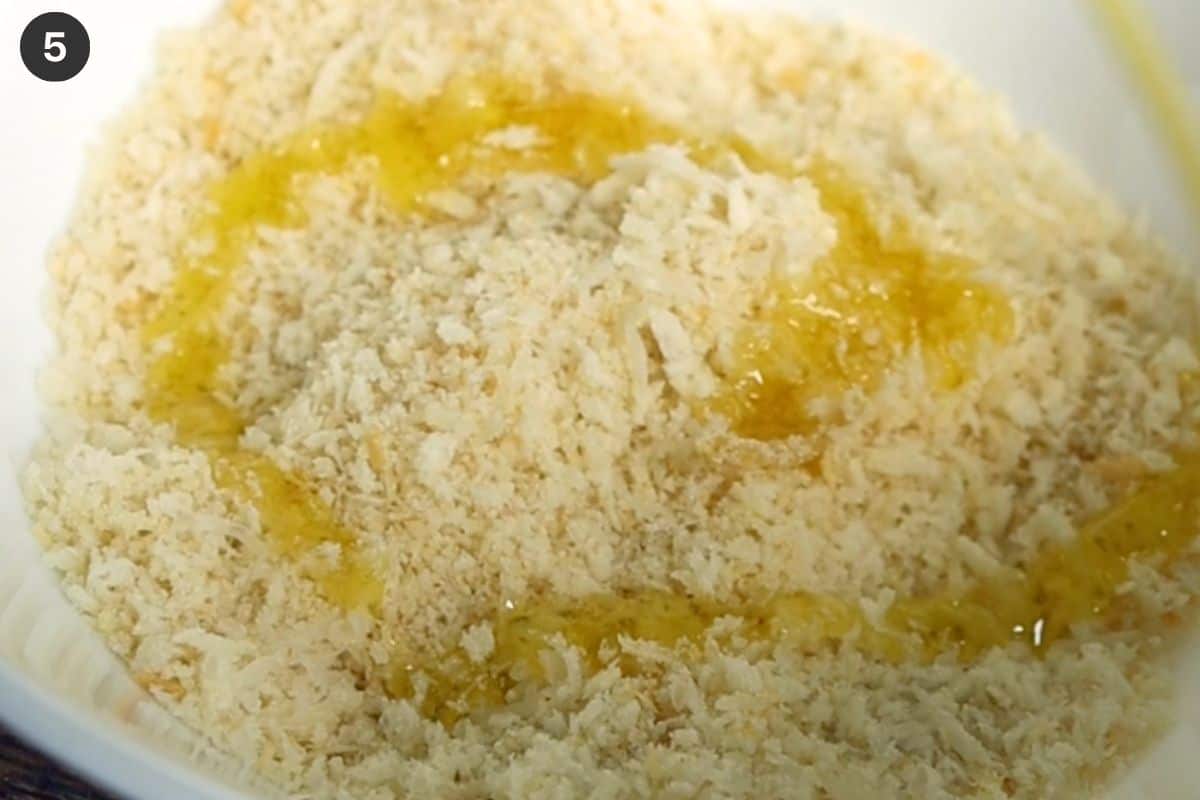 Breadcrumbs, oil and cheese in a bowl