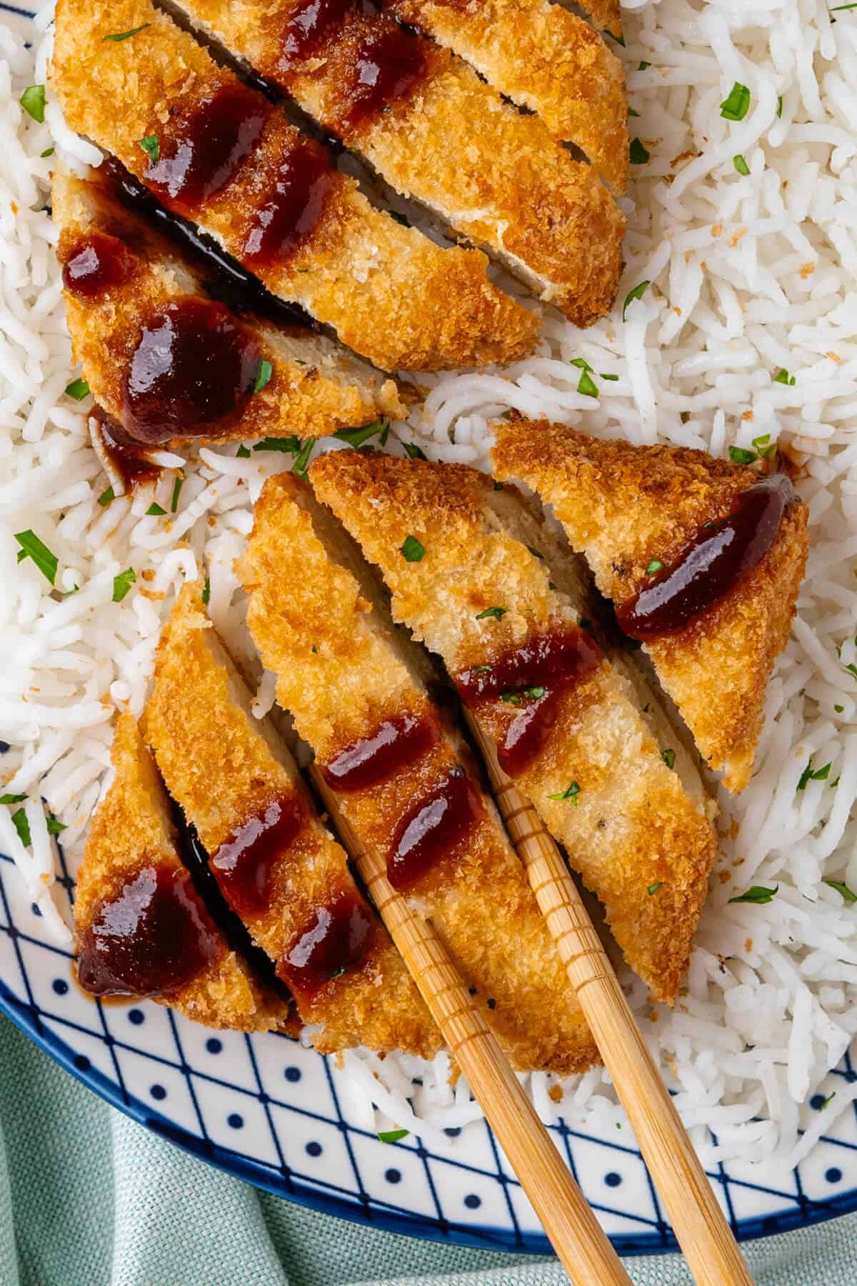 Chopsticks picking up a piece of tofu