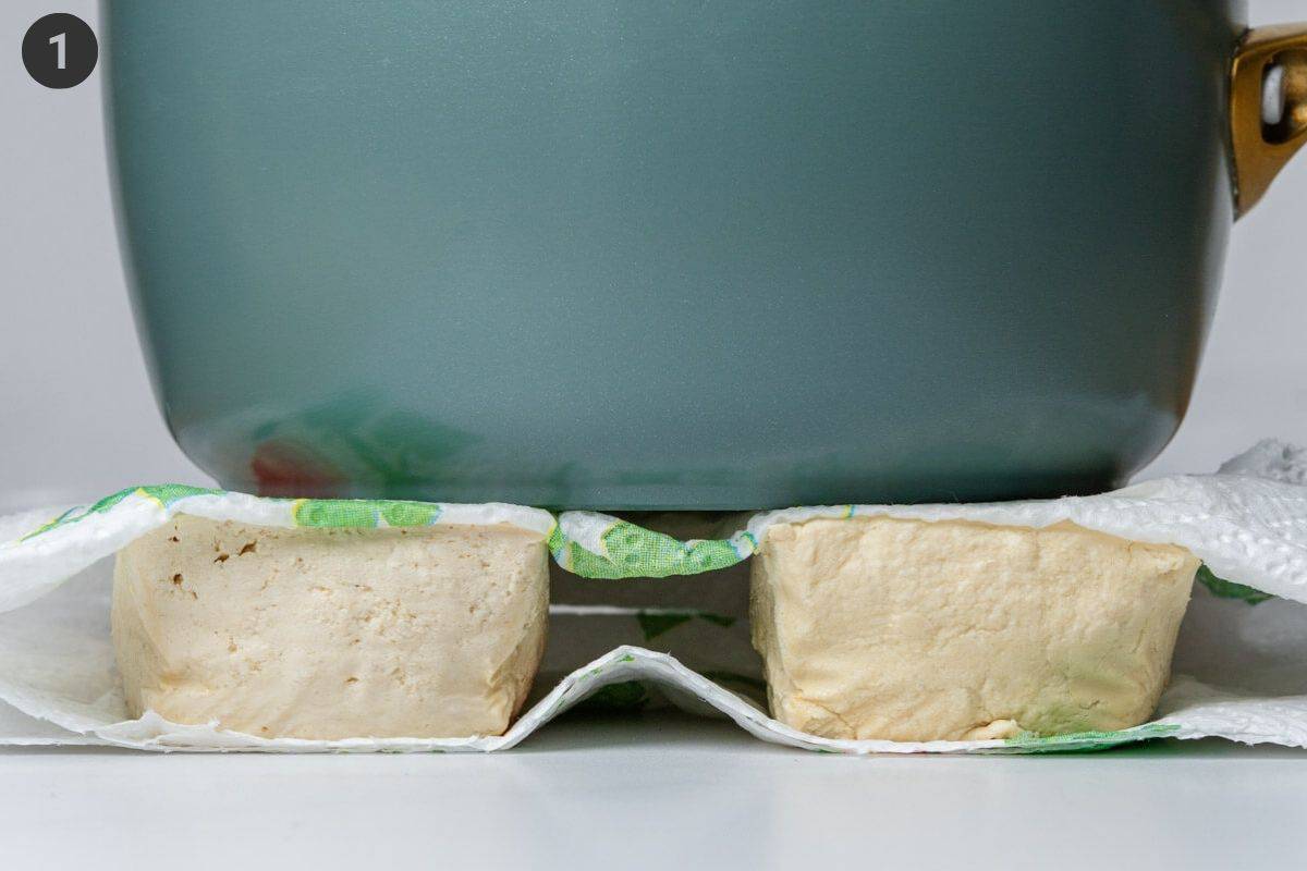 Tofu pieces being pressed to remove excess water