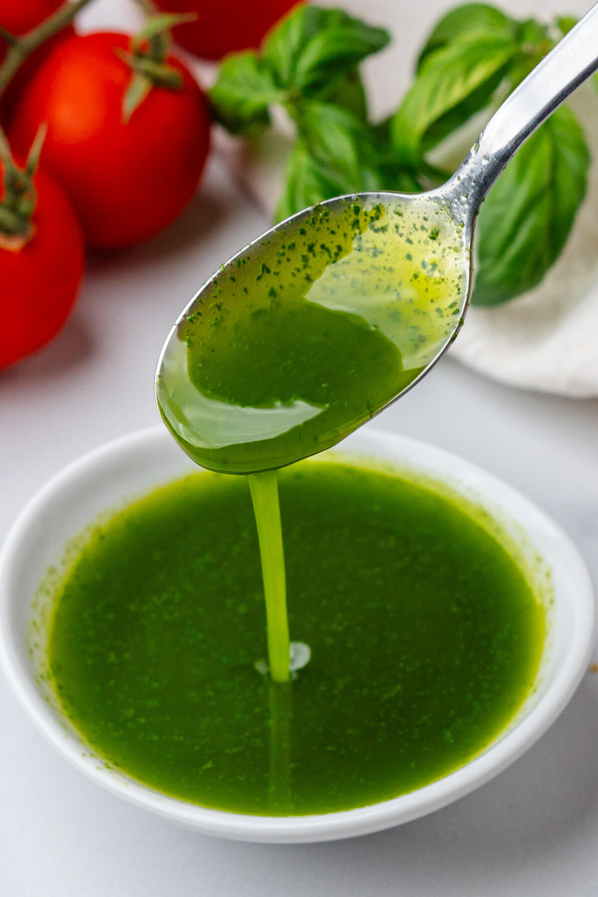 Spoon coming out of a ramekin of basil oil