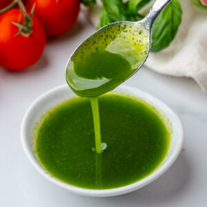 Spoon of basil oil in a small ramekin