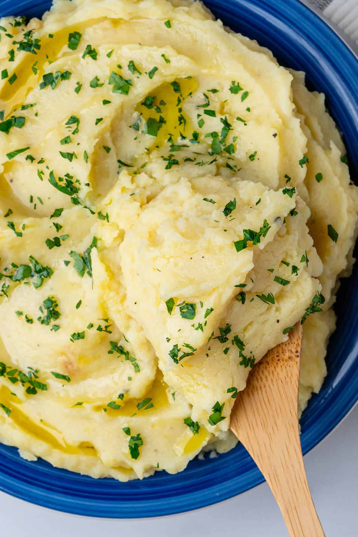 Wooden spoon in a bowl of mashed potatoes