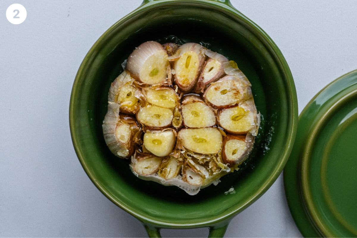 Garlic head in a small pot with olive oil