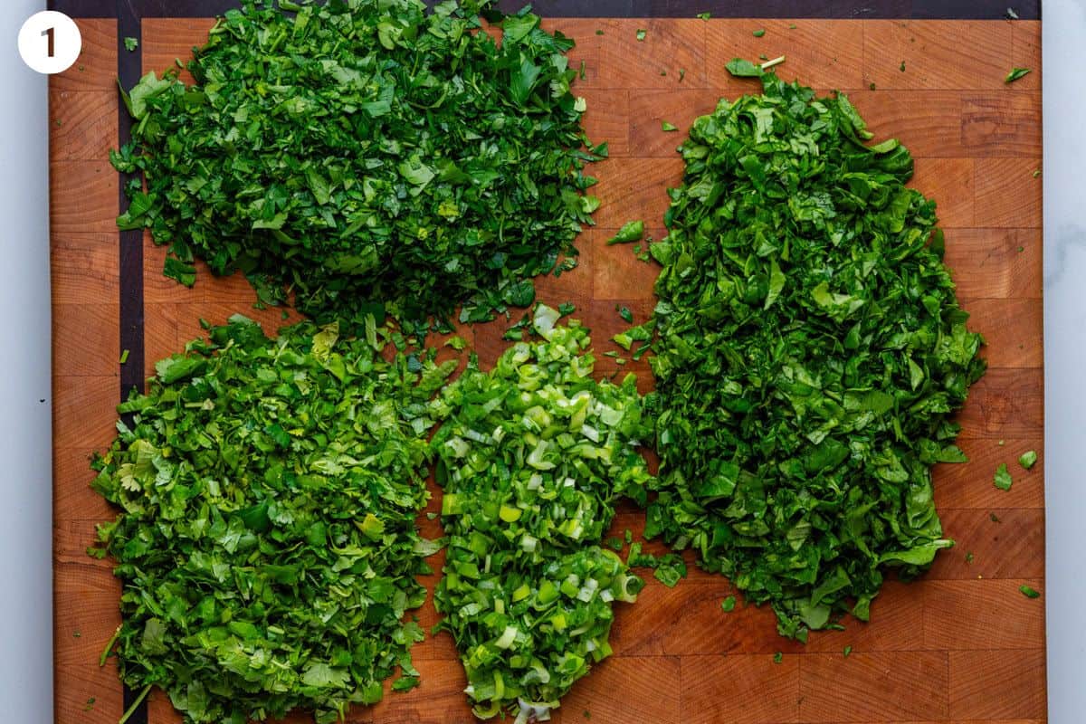 Fresh herbs and greens chopped on a cutting board