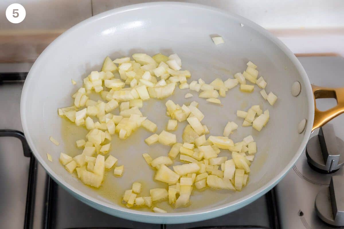 Onion being sautéed in a pan