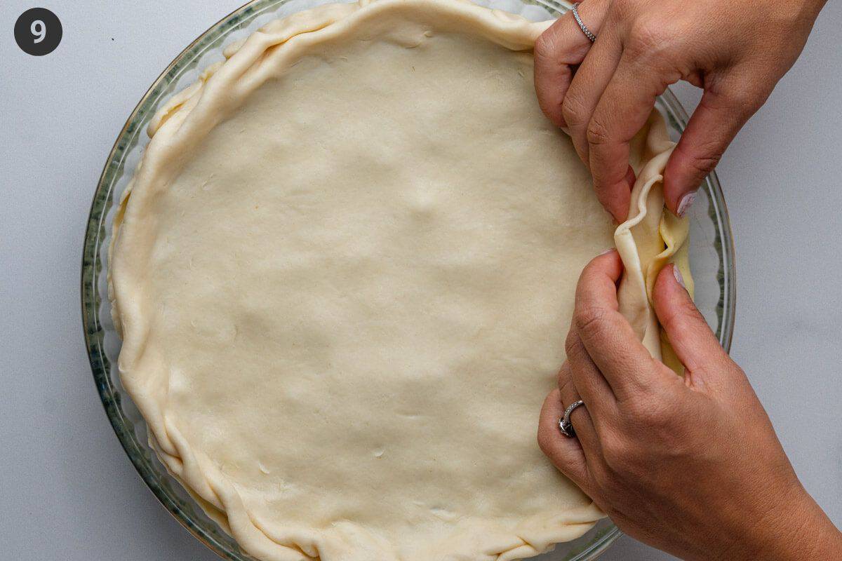 Puff pastry on top being folded into the pie crust