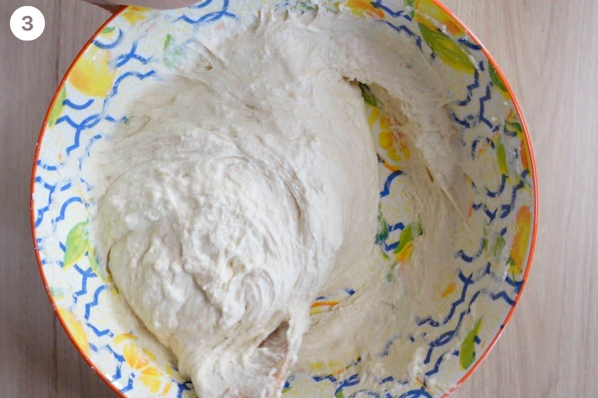 Focaccia dough being mixed with a wooden spoon