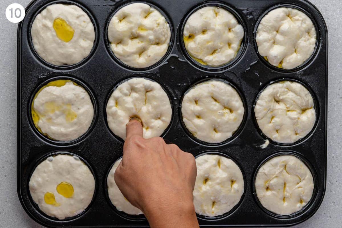 Fingers dimpling the dough in the muffin tin