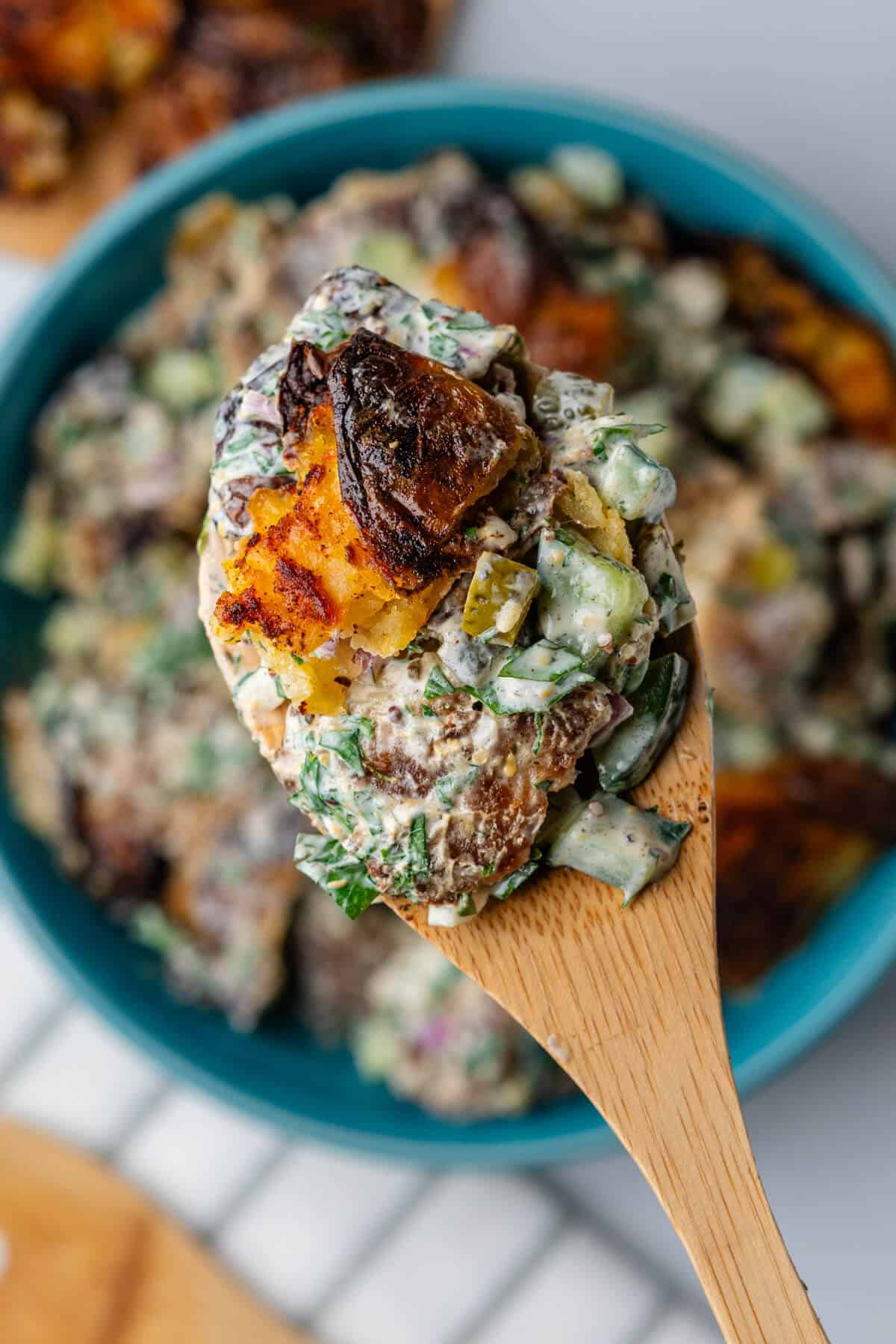 Close up of spoon with crispy smashed potato salad