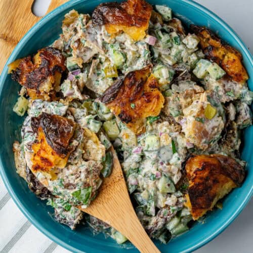 Crispy Smashed Potato Salad in a bowl with wooden spoon