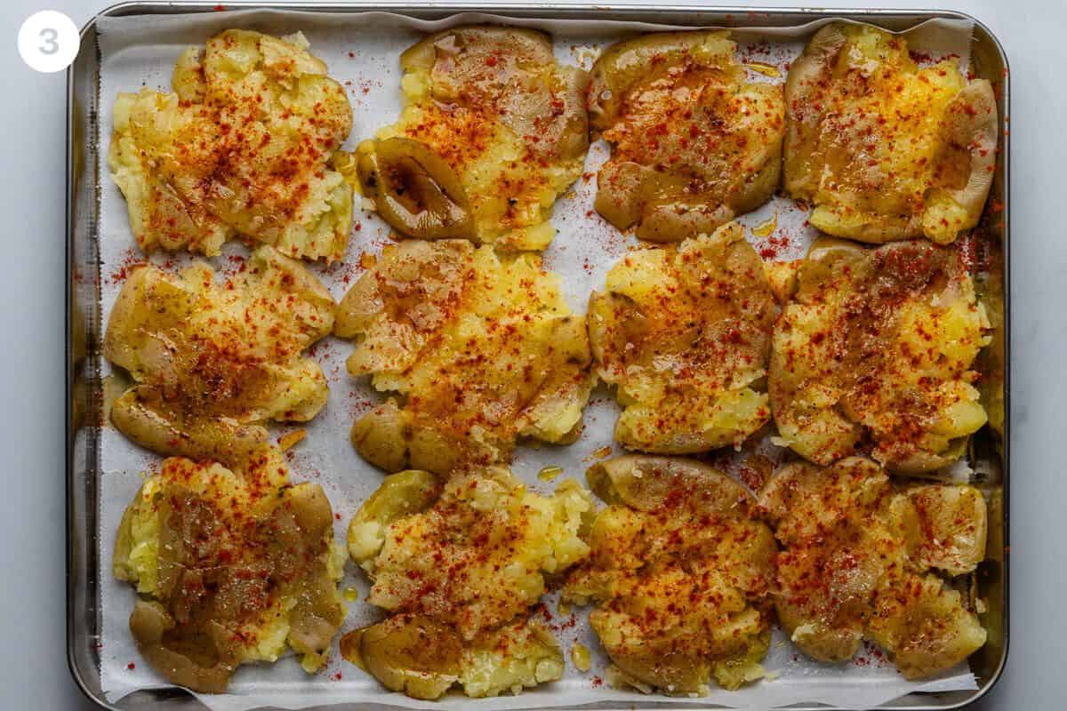 Smashed potatoes seasoned before going in the oven