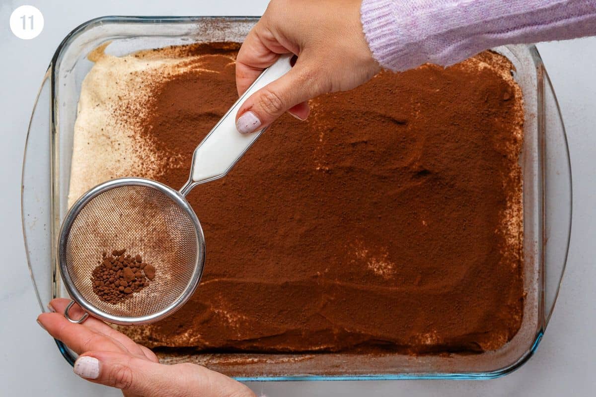 Cacao powder being added on top of tiramisu before serving