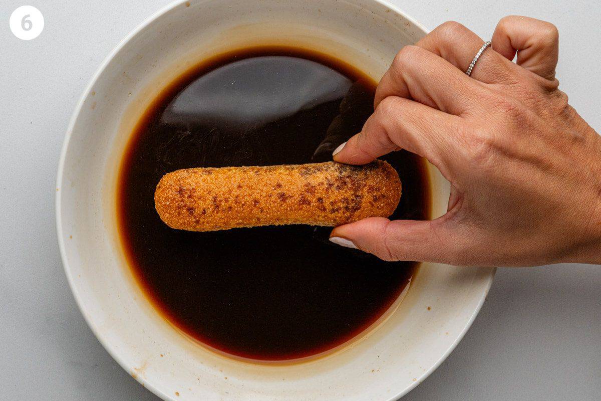 Biscuit being dipped into coffee mixture