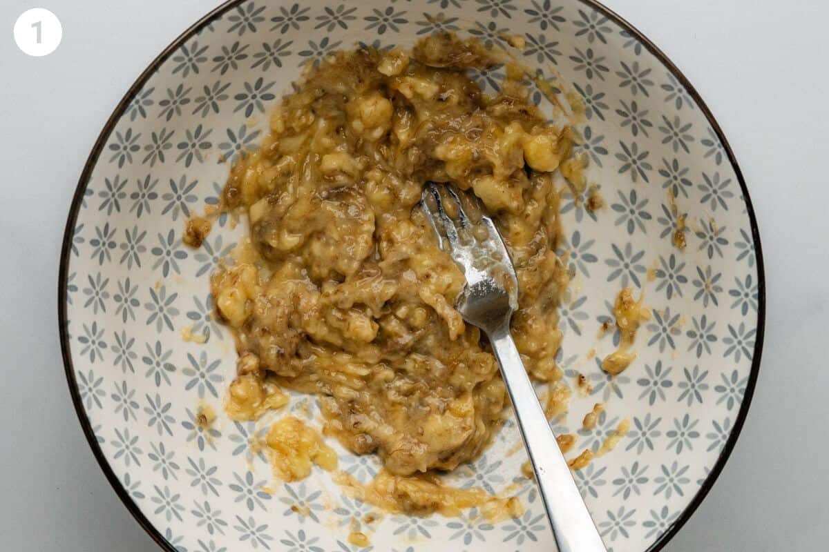 Banana mashed with a fork in a bowl