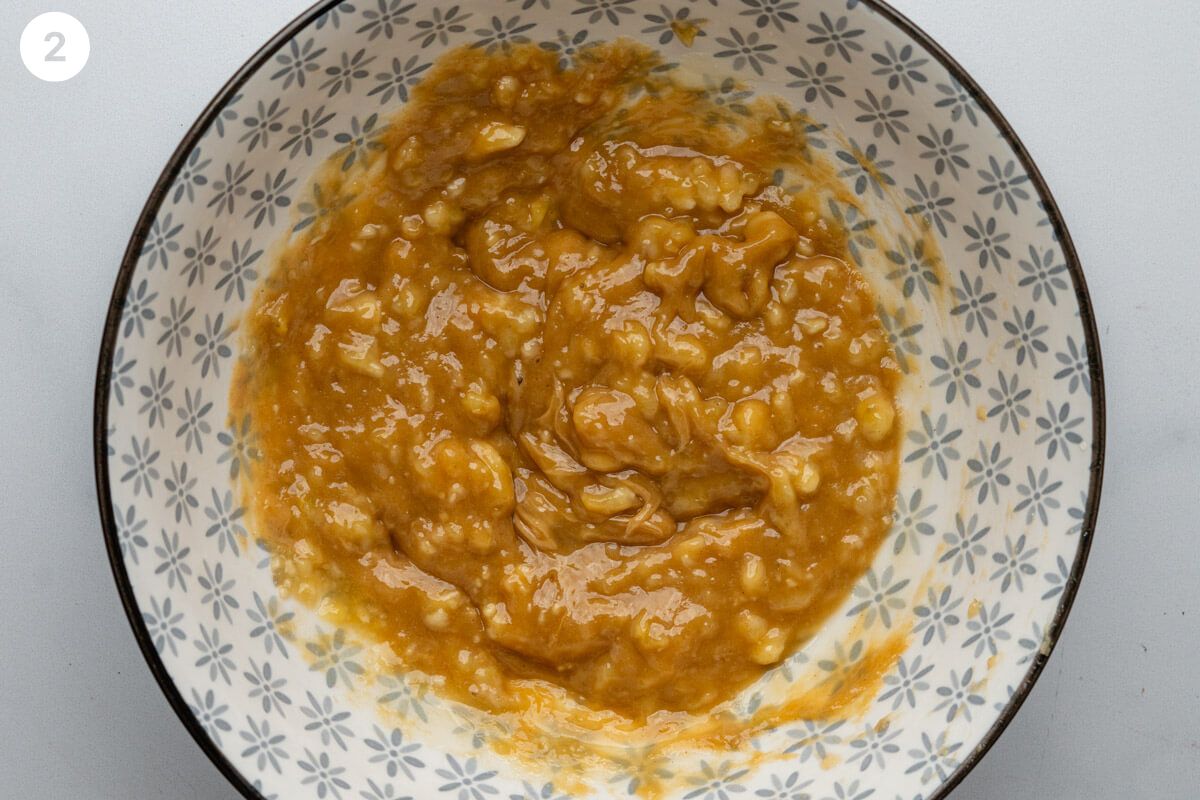 Peanut butter added to mashed banana in a bowl