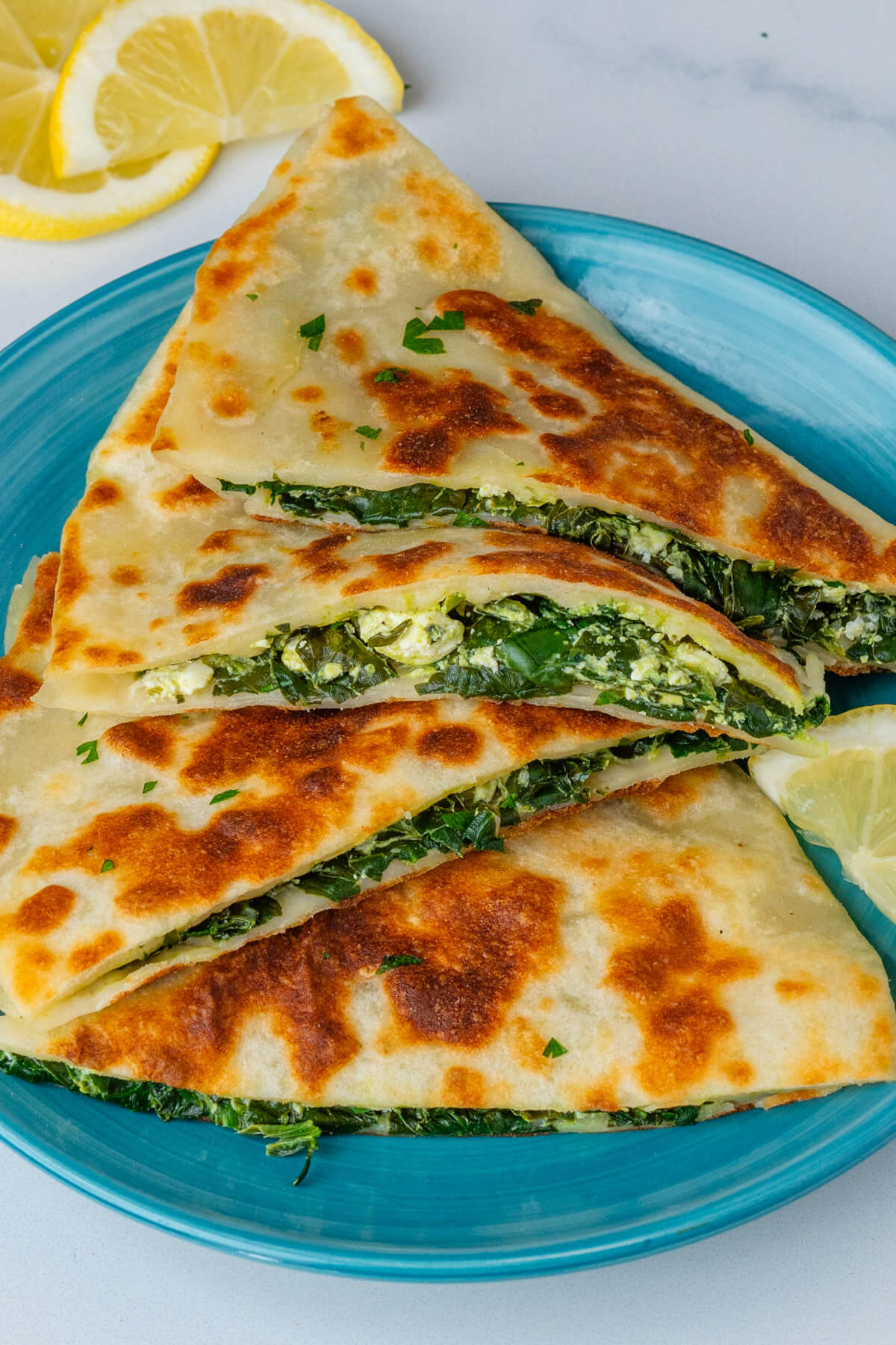 Pieces of Turkish gozleme on a plate served with lemon