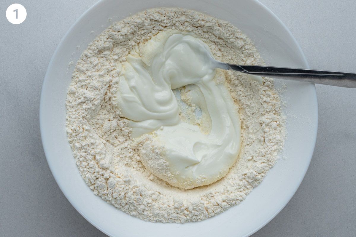 Flour and yogurt in a bowl with a spoon